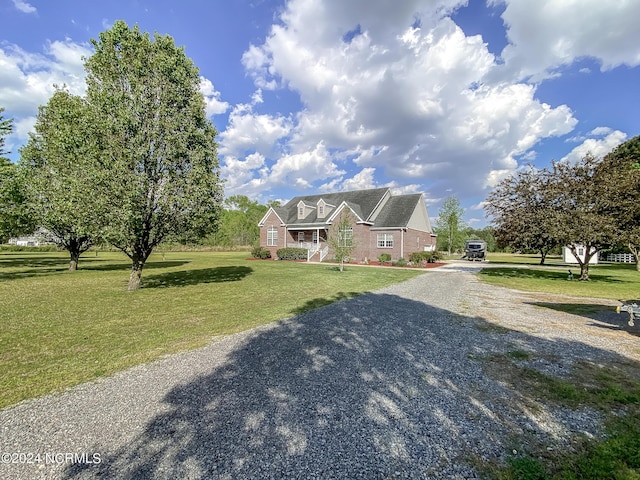 view of front facade featuring a front lawn and gravel driveway