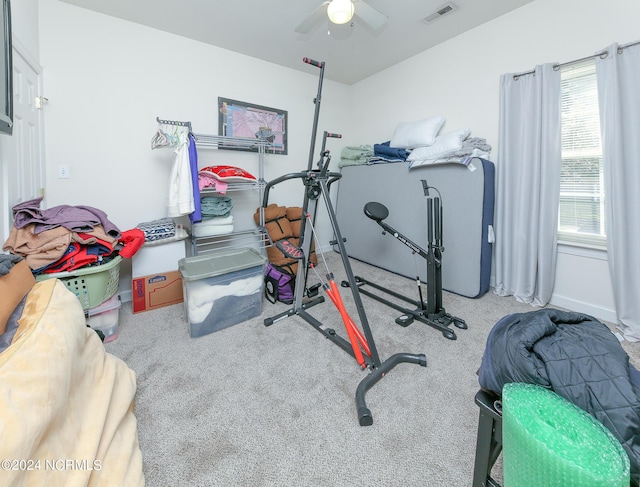 exercise area featuring carpet, visible vents, and a ceiling fan