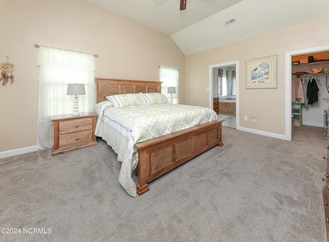 bedroom with a walk in closet, visible vents, light carpet, vaulted ceiling, and baseboards