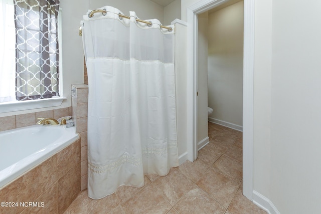 full bath with a relaxing tiled tub, a tile shower, and tile patterned floors