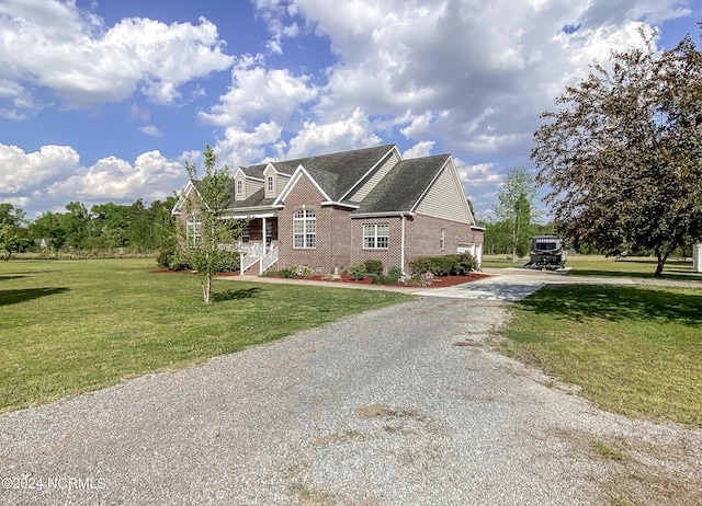 view of front of house with driveway, a front lawn, and brick siding