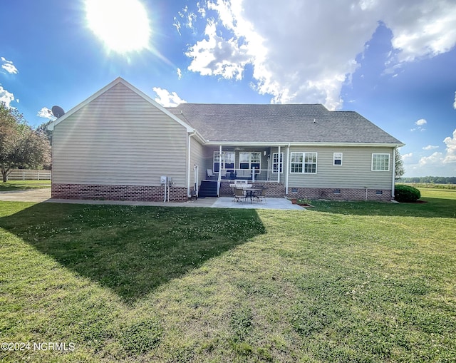 rear view of house featuring crawl space, a lawn, and a patio