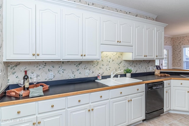 kitchen with dishwasher, white cabinets, crown molding, sink, and light tile patterned flooring