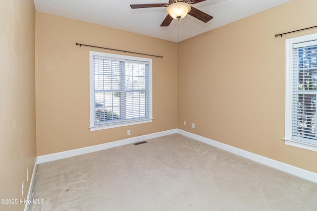 carpeted empty room with ceiling fan and a textured ceiling