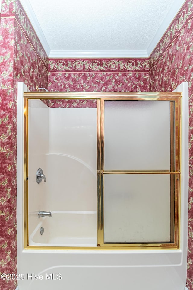 bathroom featuring a textured ceiling, shower / bath combination with glass door, and crown molding