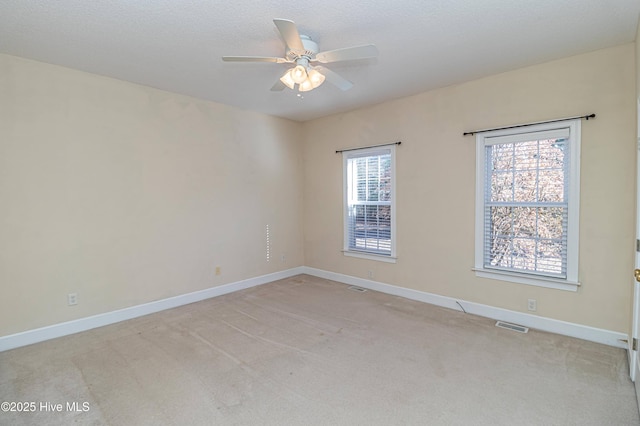 unfurnished room featuring light carpet, plenty of natural light, and ceiling fan