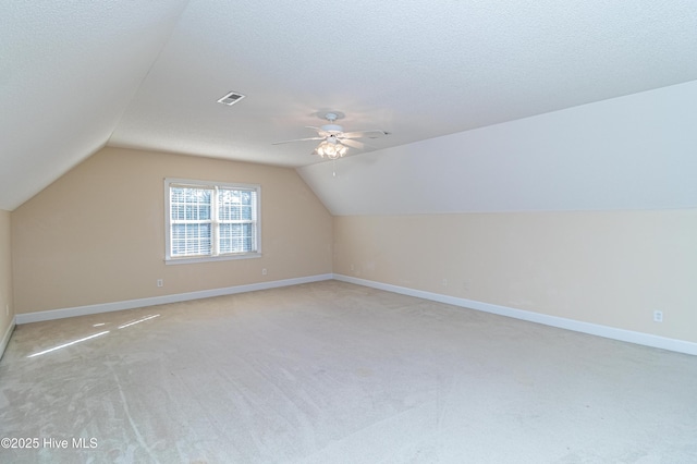 bonus room featuring ceiling fan, light colored carpet, a textured ceiling, and vaulted ceiling