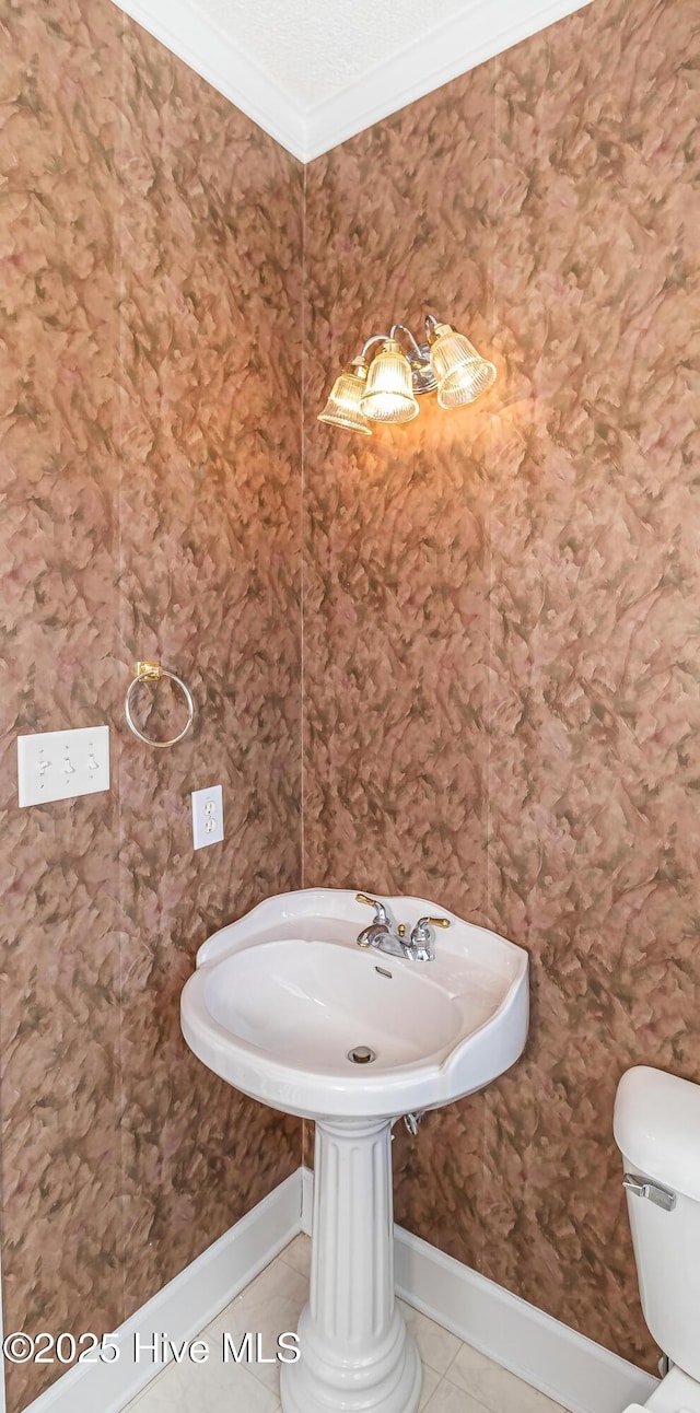 bathroom featuring toilet, tile patterned flooring, and ornamental molding