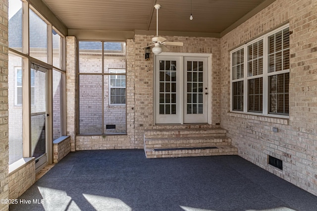 unfurnished sunroom featuring ceiling fan