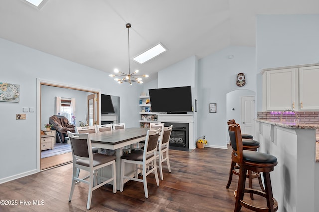 dining space with dark wood-type flooring, a chandelier, and high vaulted ceiling