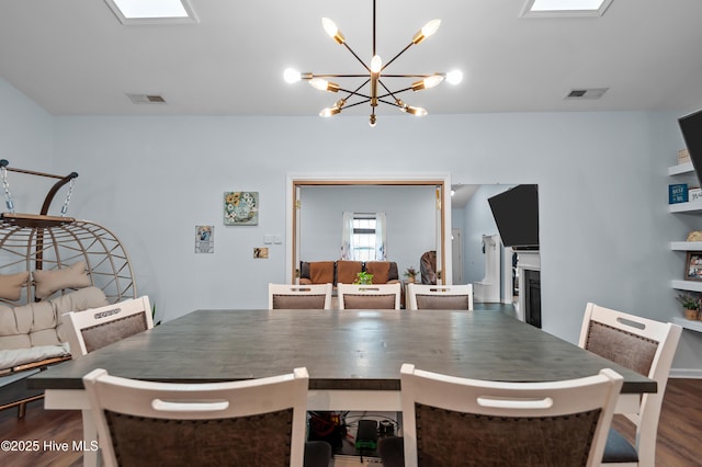 dining area featuring dark hardwood / wood-style flooring and a notable chandelier