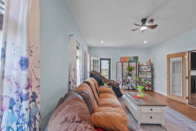 living room featuring french doors, ceiling fan, and light wood-type flooring