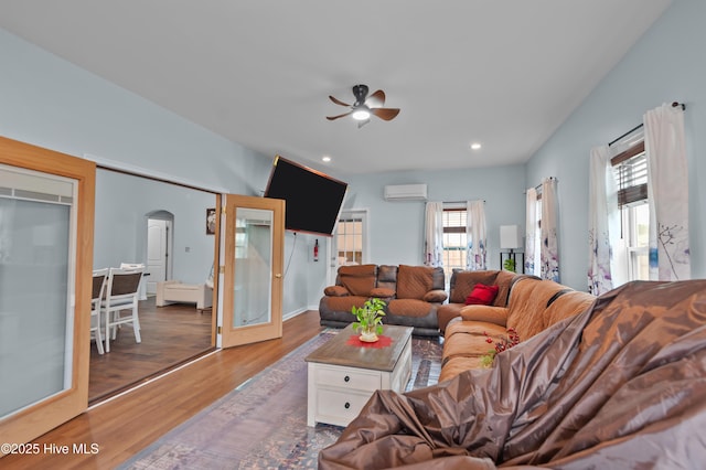 living room featuring hardwood / wood-style flooring, an AC wall unit, and ceiling fan