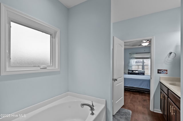 bathroom featuring vanity, a tub to relax in, hardwood / wood-style flooring, and ceiling fan