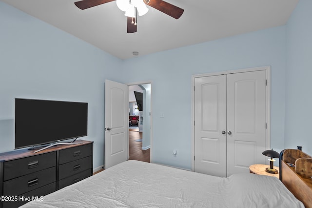 bedroom featuring dark hardwood / wood-style flooring, ceiling fan, and a closet