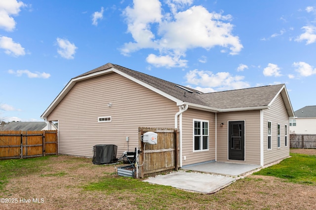 rear view of house featuring central AC, a patio, and a lawn