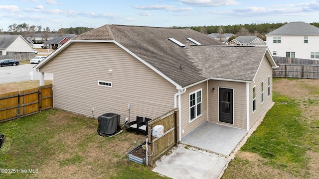 back of house featuring a lawn, a patio, and central air condition unit