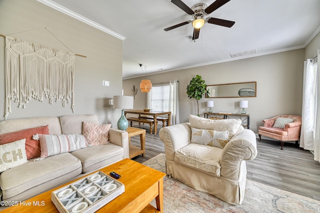 living room featuring ornamental molding, hardwood / wood-style floors, and ceiling fan