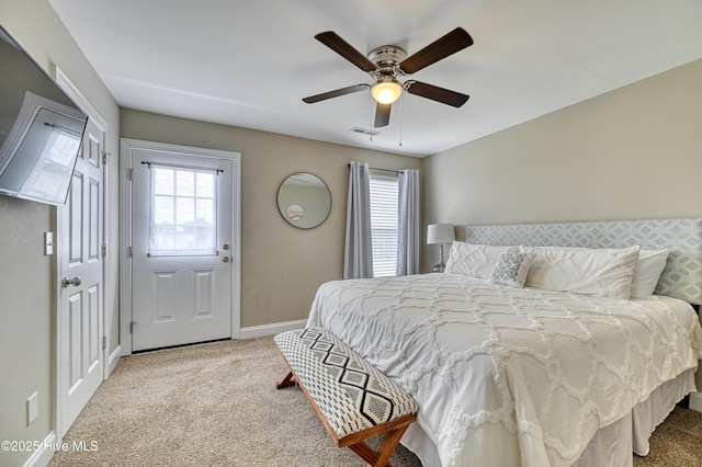 carpeted bedroom with ceiling fan and multiple windows