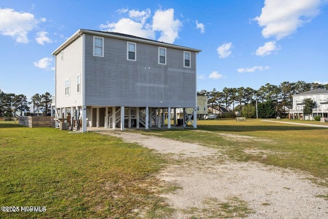 rear view of property with a carport and a lawn