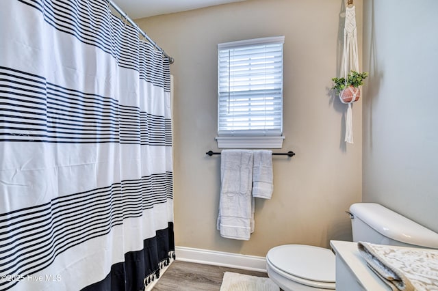 bathroom featuring hardwood / wood-style flooring and toilet