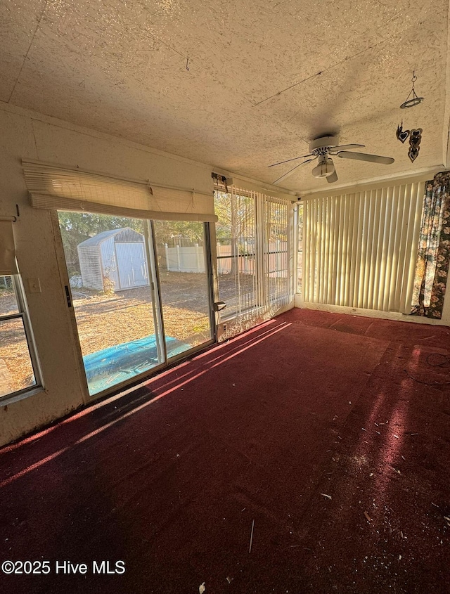 unfurnished sunroom featuring ceiling fan