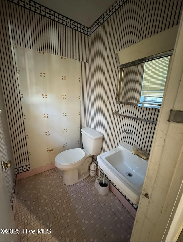 bathroom featuring toilet and tile patterned floors