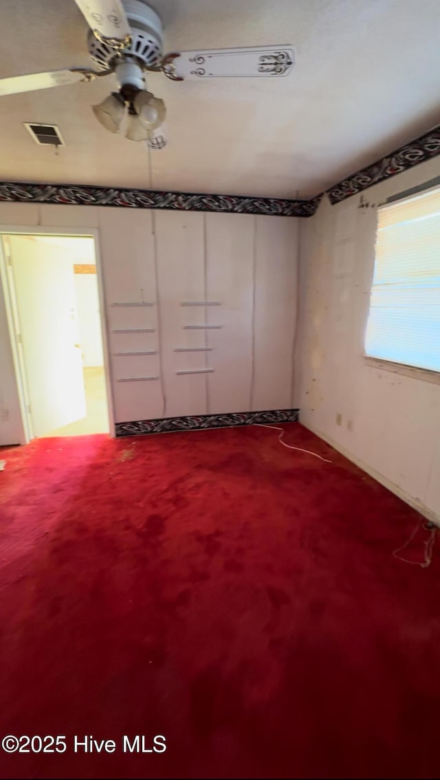 unfurnished bedroom with ceiling fan and carpet