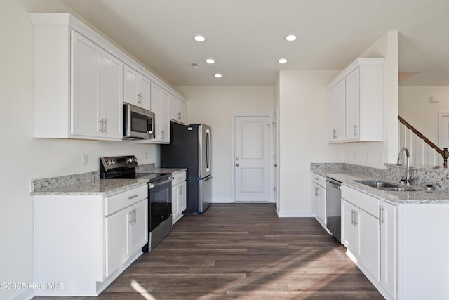 kitchen with light stone countertops, sink, white cabinets, and appliances with stainless steel finishes