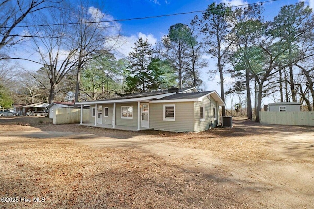 view of front of home featuring central AC unit, fence, and a porch