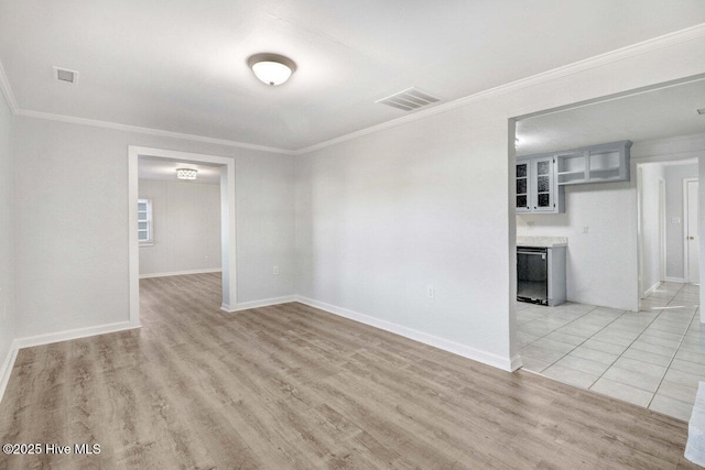 unfurnished room featuring crown molding and light wood-type flooring