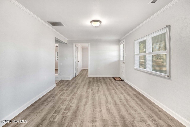 empty room featuring light hardwood / wood-style flooring and ornamental molding