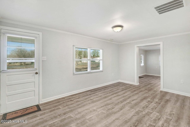 spare room featuring ornamental molding and light hardwood / wood-style floors