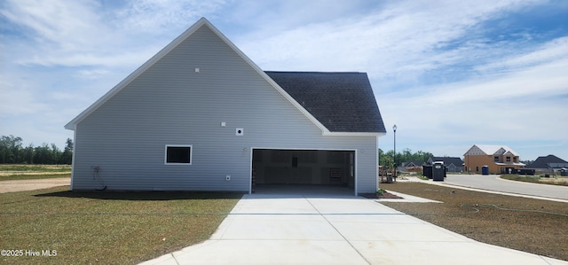 2040 Bluewater Blvd, New Bern, NC 28562 - view of property exterior with a garage, driveway, roof with shingles, and an outbuilding