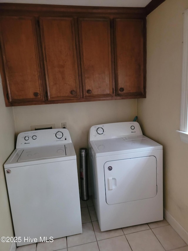 laundry area with cabinets, light tile patterned floors, and separate washer and dryer