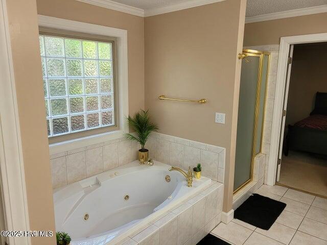 bathroom with plus walk in shower, tile patterned flooring, a wealth of natural light, and ornamental molding