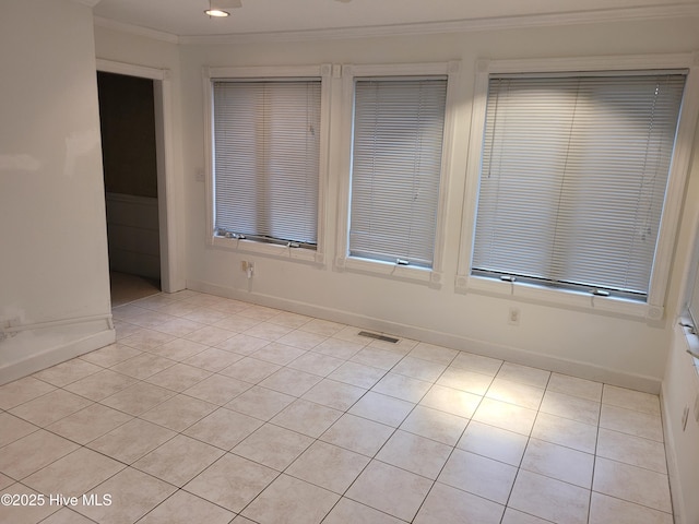 unfurnished room with crown molding and light tile patterned flooring