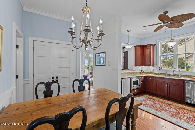 living room with ceiling fan, ornamental molding, a brick fireplace, and hardwood / wood-style floors