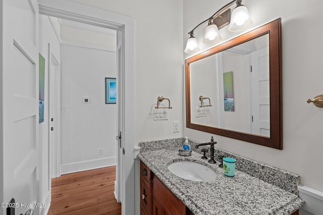 kitchen featuring light stone countertops, high end appliances, and wall chimney exhaust hood