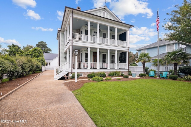 view of front of house featuring a porch, a front lawn, a balcony, and ceiling fan