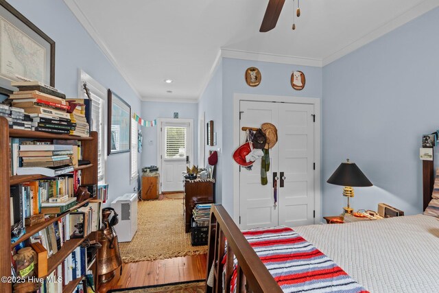 bedroom featuring ceiling fan, a closet, crown molding, and wood-type flooring