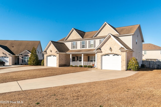 front of property featuring a porch, a garage, and central AC