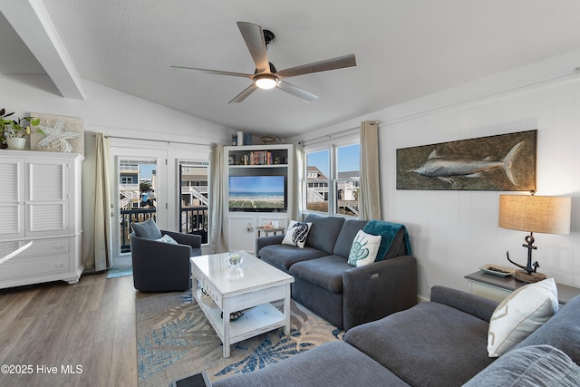 living room with hardwood / wood-style floors, a textured ceiling, ceiling fan, and lofted ceiling