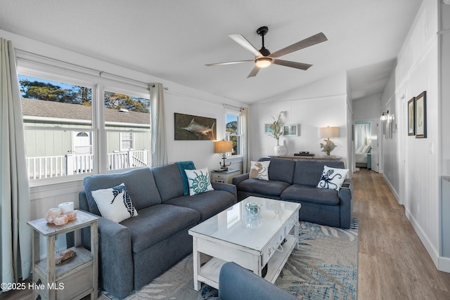 living room with ceiling fan, lofted ceiling, and light hardwood / wood-style flooring