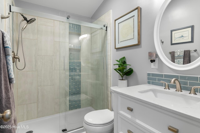 bathroom featuring vanity, backsplash, toilet, and an enclosed shower