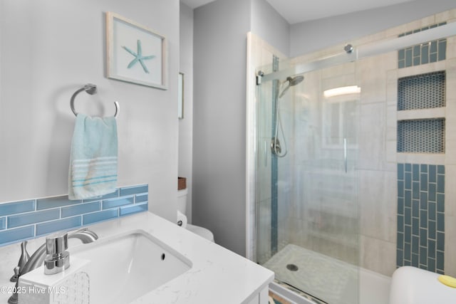 bathroom with tasteful backsplash, vanity, an enclosed shower, and toilet