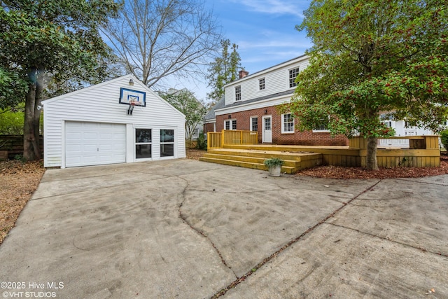 exterior space with a garage, an outdoor structure, and a wooden deck