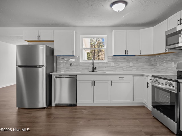 kitchen with sink, stainless steel appliances, white cabinets, and dark hardwood / wood-style floors