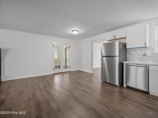 kitchen featuring appliances with stainless steel finishes, dark hardwood / wood-style flooring, white cabinets, and decorative backsplash