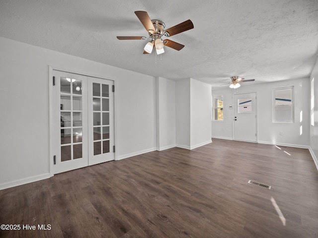 unfurnished living room featuring a textured ceiling, ceiling fan, french doors, and dark hardwood / wood-style floors